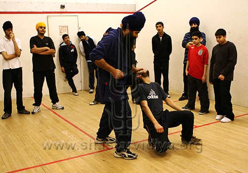 Nidar Singh Nihang demonstrating Sava Rakhsha techniques to children, London