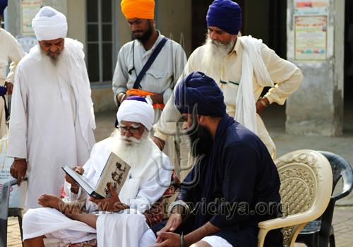 Gurdev Nidar Singh Nihang discussing his book with the revered Nihang elder, Baba Daya Singh Bidhi Chandia at Sursingh, India